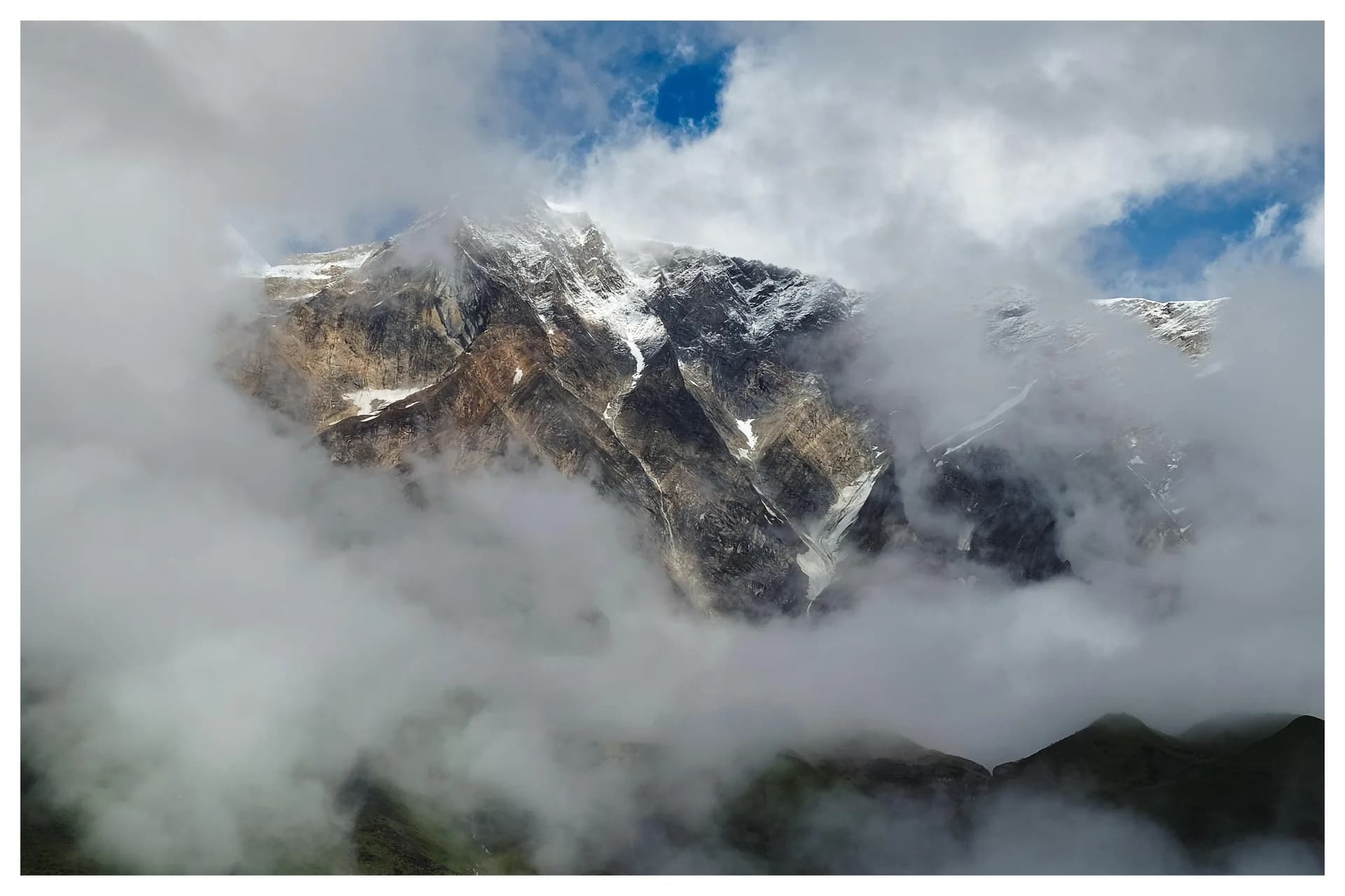 Snow peak wrapped in cloud at dawn