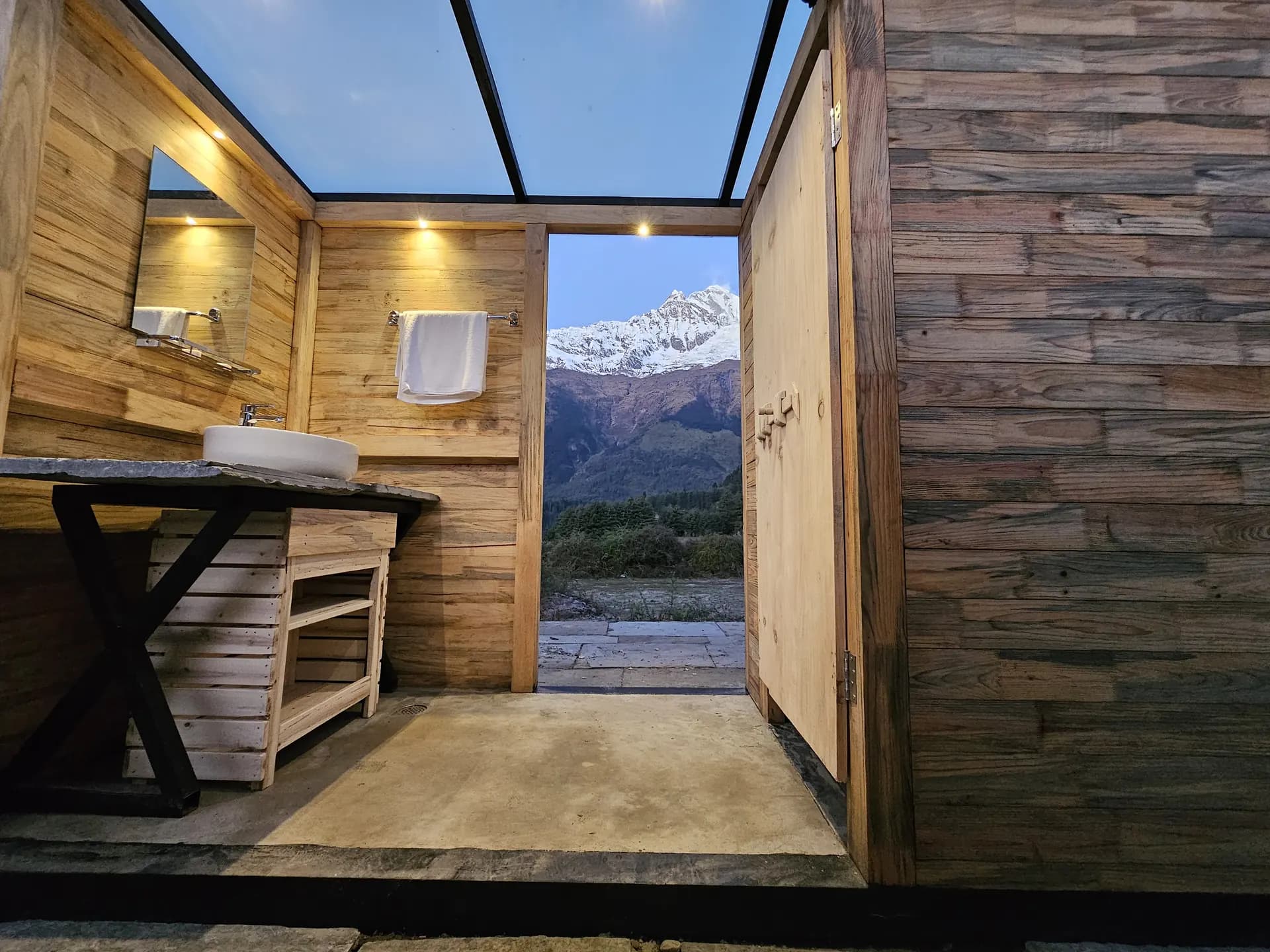 Timber washroom opening onto the Annapurna range at dawn