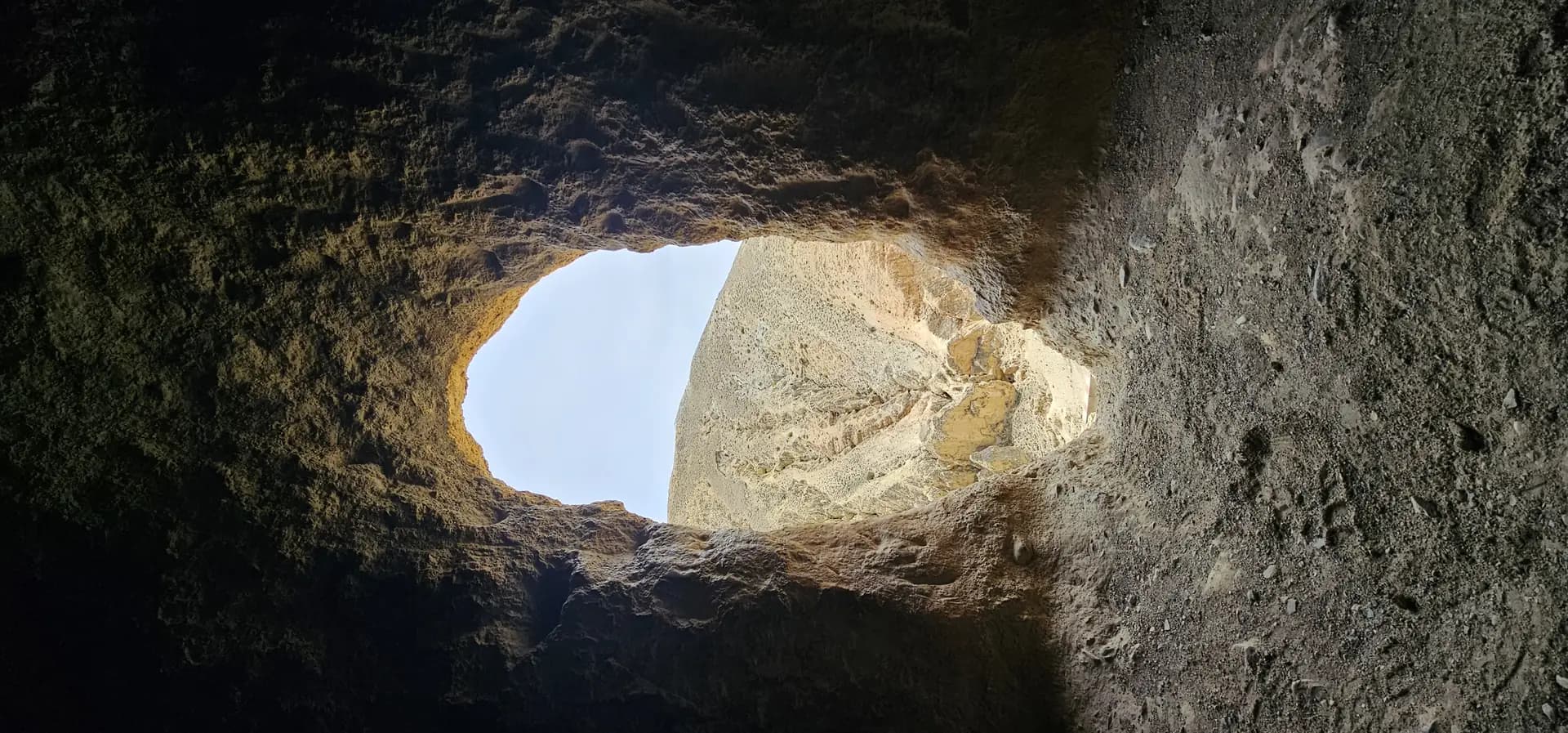Sky seen through a cliff cave opening