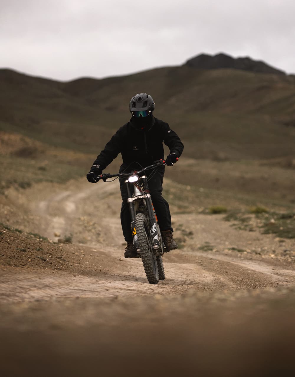 E-bike rider on a dirt track across the high desert hills